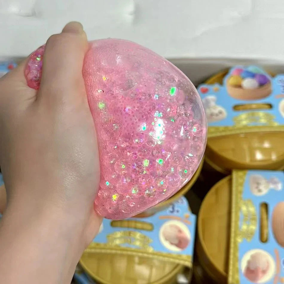 Squeezing a pink glitter dumpling squishy